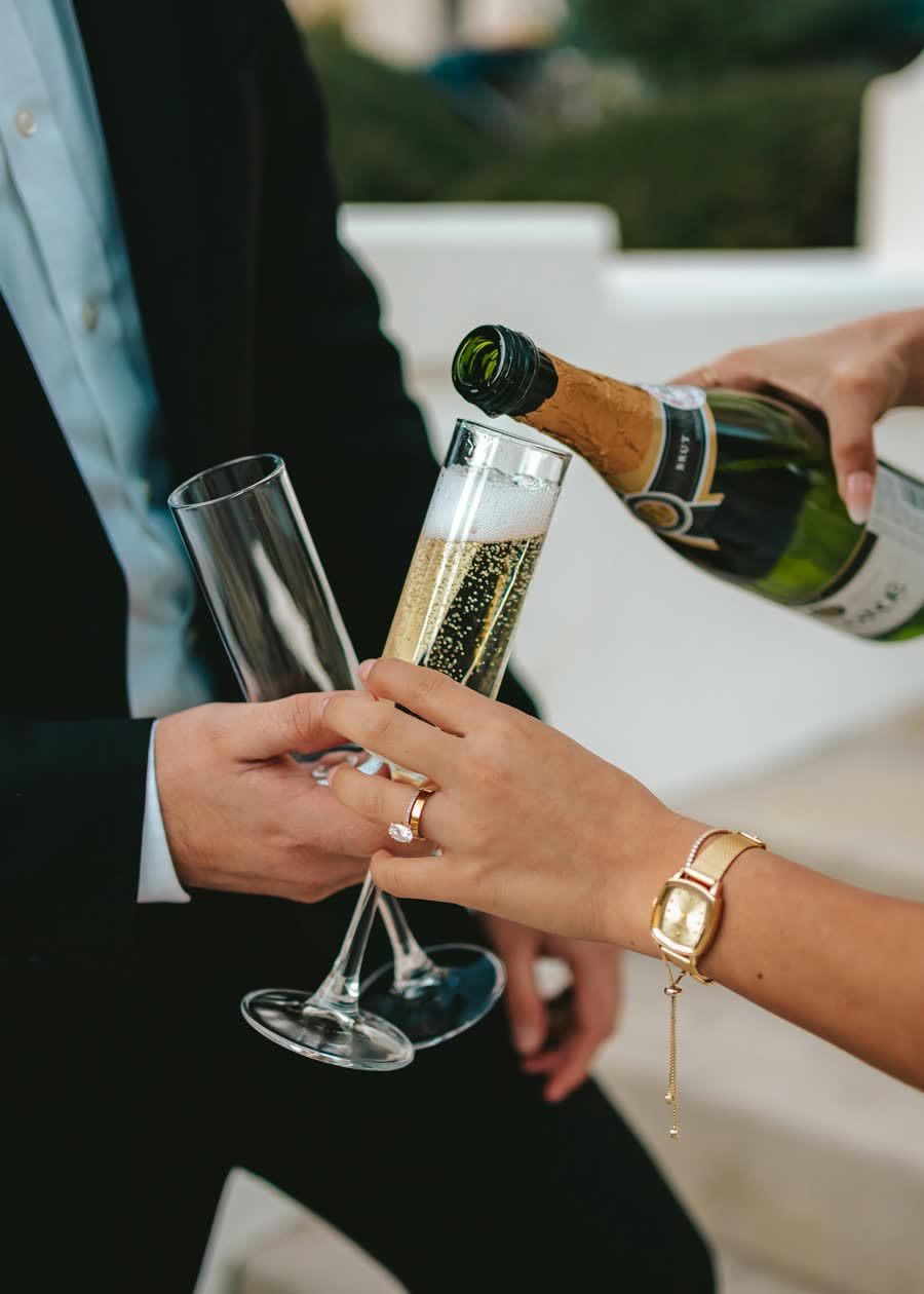 Champagne being poured into two glasses for a couple